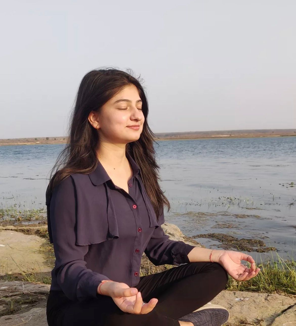 Dr. Anchal Sharma in meditation by the water