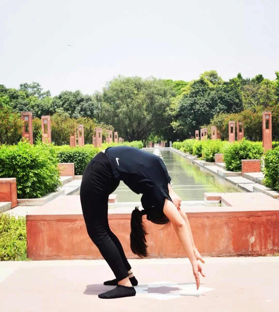 Dr. Anchal Sharma in a standing backbend in a Delhi garden