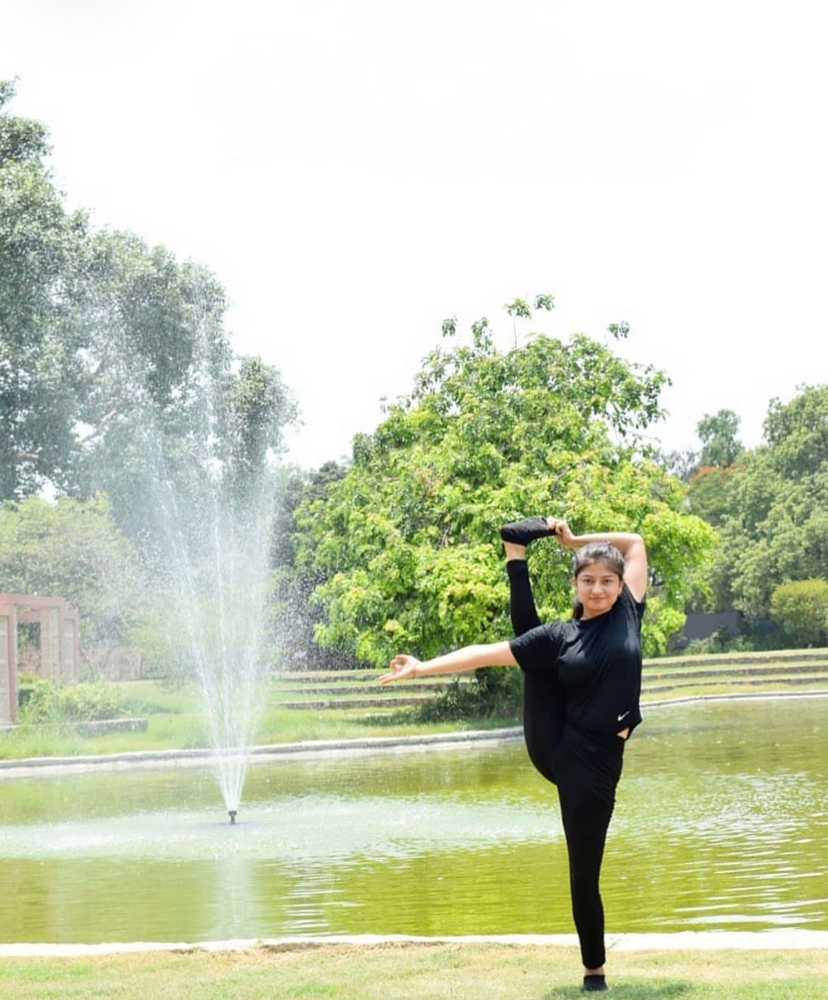 Dr. Anchal Sharma in Natarajasana by a fountain in New Delhi